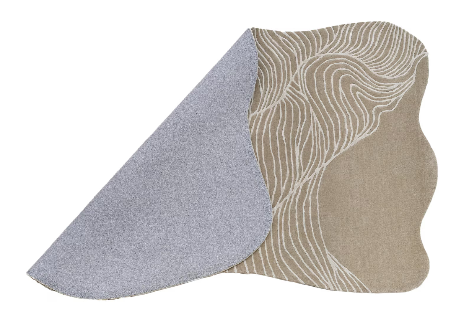 wavy abstract beige rug hand tufted rug with flowing white line pattern shown partially folded with grey backing on a white background